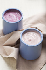 Yogurts assortment  in ceramic bowls on wooden ligth background. Natural and fruit  healthy, diet, gourmet dessert for granola breakfast. Sweet yogurts closeup.