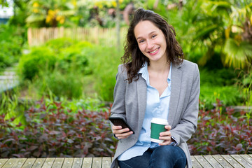 Young attractive business woman working at the park during a pau