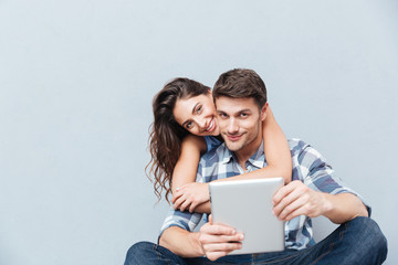 Couple sitting at home and using digital tablet