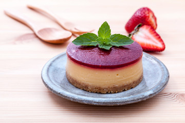 Strawberry cheesecake with fresh mint leaves on wooden backgroun