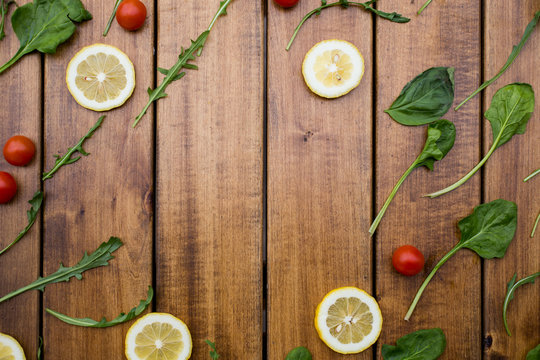 Tomatoes, herbs, lemone, red pepper on a wooden background