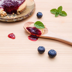 Blueberry cheesecake with fresh mint leaves on wooden background