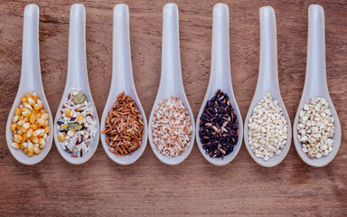 Assortment of traditional thai rice in spoon on wooden backgroun