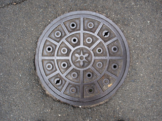 Circle steel manhole cover or metal sewer on the street