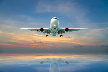 Fototapeta na wymiar Airplane flying tropical sea at sunset time.