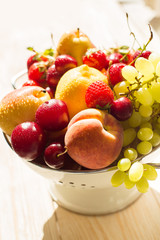 Fresh mixed fruits, berries in colander. Love fruit, berry. Sunlight