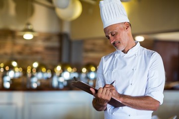 Chef writing on a clipboard
