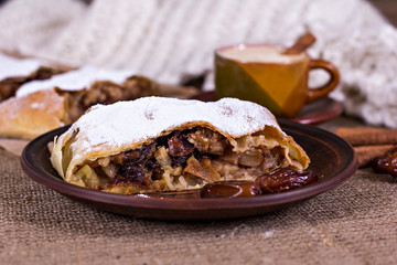 A cup of coffee, cinnamon, cake, knitted scarf - winter still life