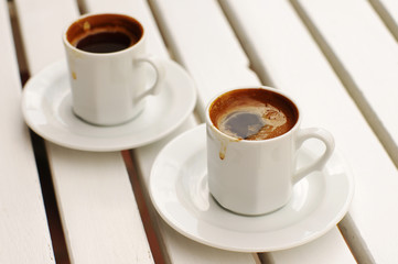 Two cups of coffee. Coffee cups and saucers on a white table