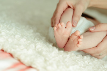 mothers hands holds baby feet