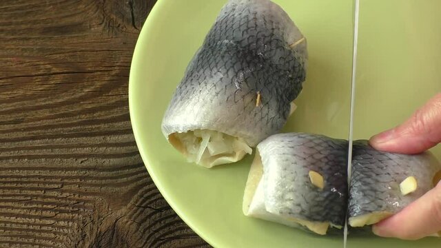 Fish rolls with sour herring on green plate
