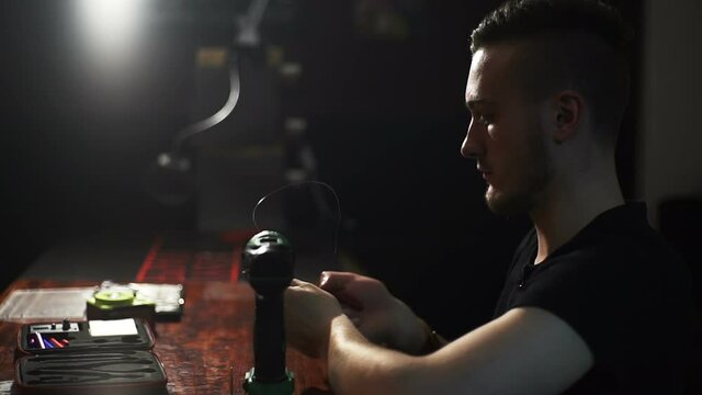 young man make a coil build on RDA in smoky vape shop