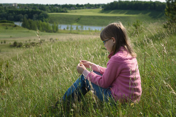 lonely girl teenager sitting on green field