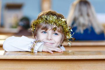 little kid boy playing an angel of Christmas story in church