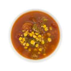 Corn okra and tomatoes soup in a white bowl top view.