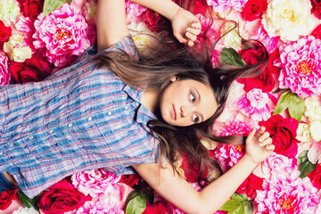 Young beautiful girl lies on the flowers.