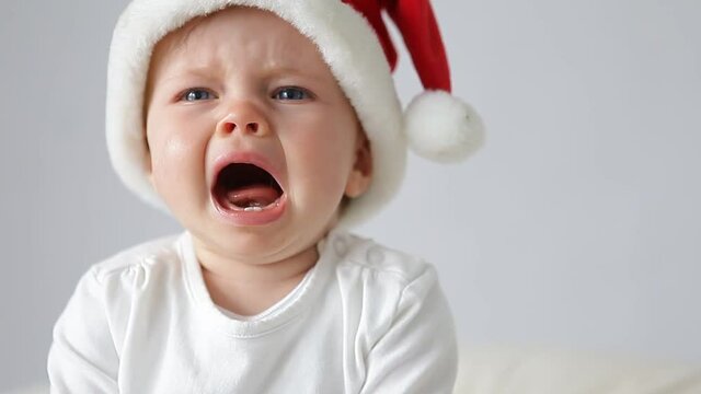 little baby with santas hat crying