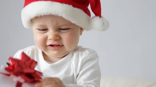 little baby with santas hat and a gift