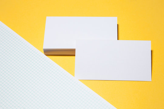 Empty business cards on yellow background - closeup shot