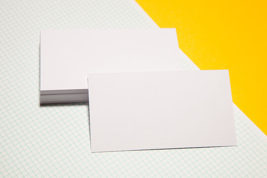 Empty business cards on yellow background - closeup shot