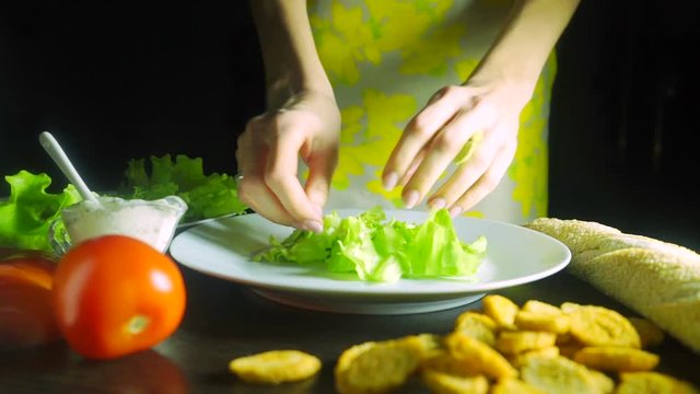 Girl with beautiful hands cooking Caesar chicken salad, close up video