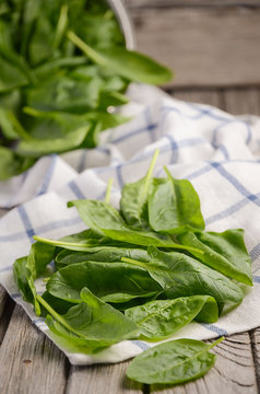 Fresh spinach leaves on rustic wooden background, selective focus, copy space