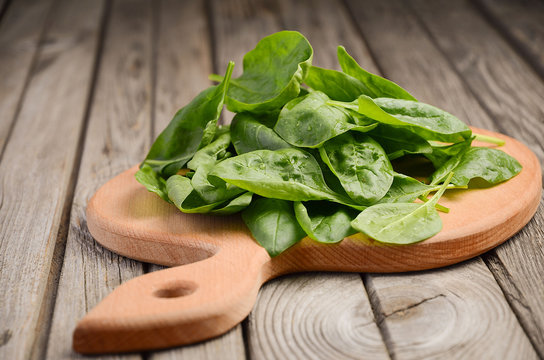 Fresh spinach leaves on rustic wooden background, selective focus, copy space