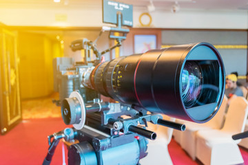 Closeup of the professional lens on video camera for film production put on the tripod.