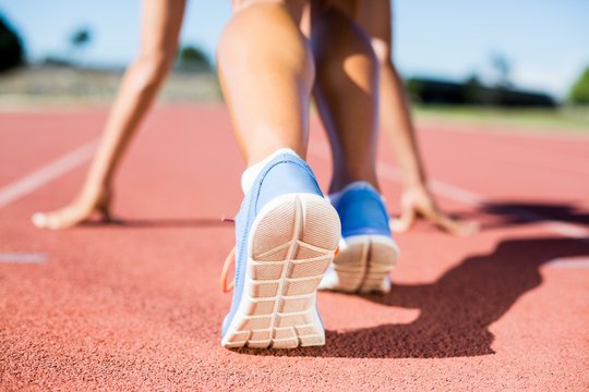 Female athlete ready to run on running track