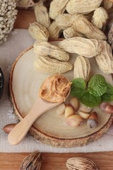 Peanut butter and peanut on wood background.