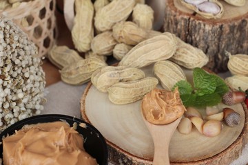 Peanut butter and peanut on wood background.