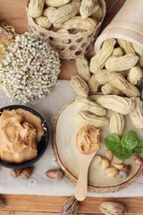 Peanut butter and peanut on wood background.
