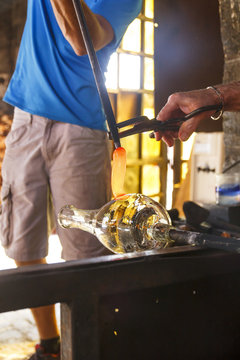 Men working with molten glass in a glass factory