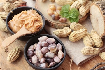 Peanut butter and peanut on wood background.