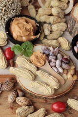 Peanut butter and peanut on wood background.
