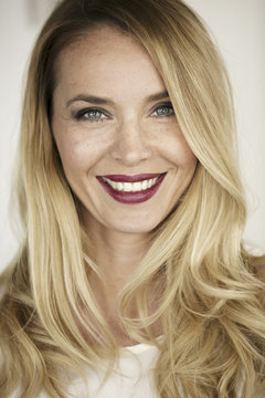Portrait of smiling blond woman with red lips