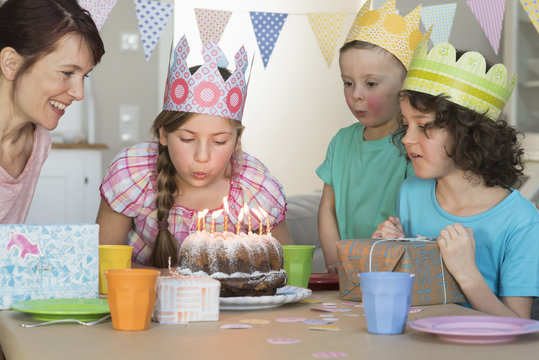 Girl blowing out candles on birthday cake