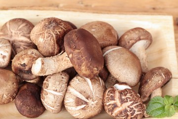 Shiitake mushrooms for cooking on wood background.