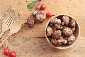 Shiitake mushrooms for cooking on wood background.