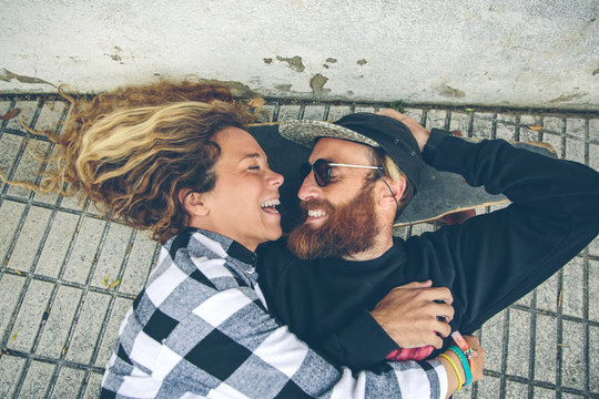 Happy couple lying on skateboard