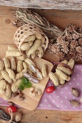 Peanut and boiled peanuts on wood background.