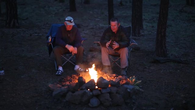 Two Men Sitting By The Campfire, Talking, Having A Good Time