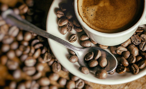 Cup of coffee with coffee beans and bokeh