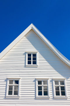 White wooden house gable against blue sky
