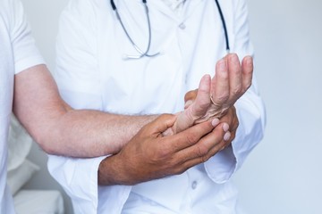 Male doctor giving palm acupressure treatment to the patient