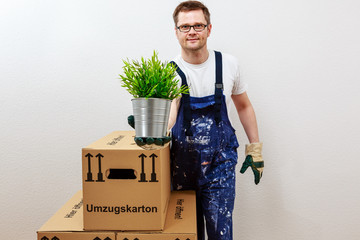 Mann überreicht mit einer Hand eine grüne Pflanze