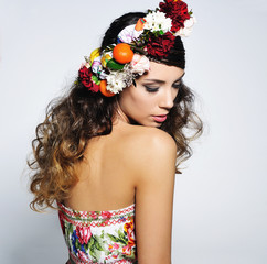 Fototapeta na wymiar Beauty portrait of a gorgeous woman with gipsy hairstyle wearing handmade fairy flower crown .