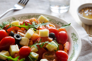 Vegetable salad with cheese and a glass of water