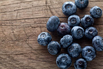Freshly picked blueberries in wooden background. Juicy and fresh blueberries with green leaves on rustic table.Concept for healthy eating and nutrition