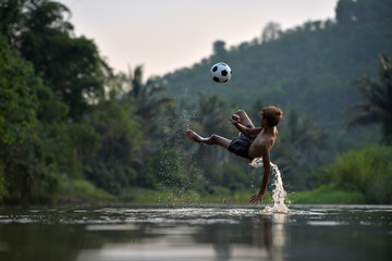 Boy playing football with kicking soccer ball - 113627160